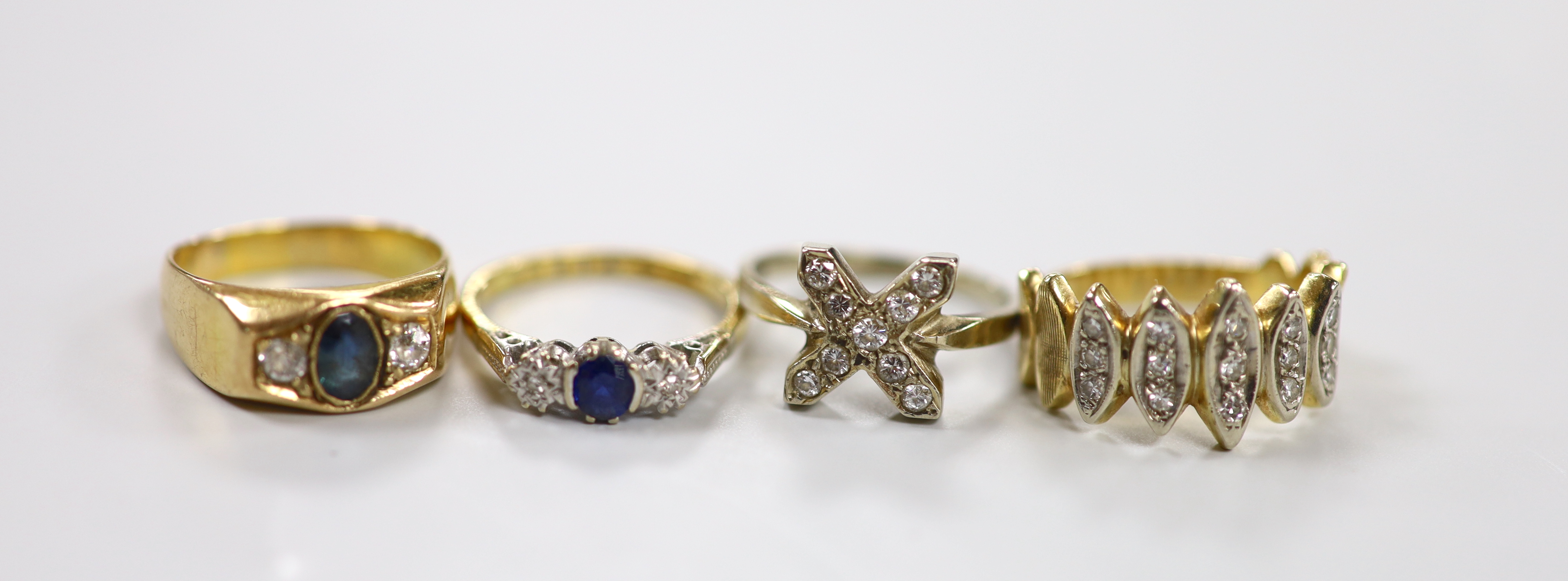 Two yellow metal, sapphire and diamond set three stone rings, one stamped 18ct, size K and two other yellow metal and diamond chip set cluster rings, gross weight 16.1 grams.